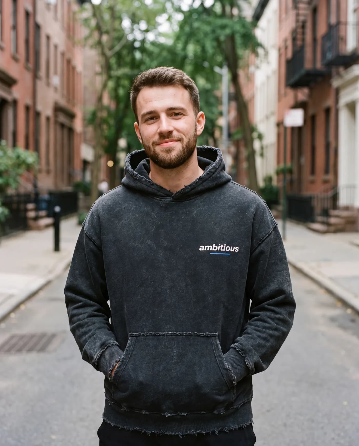 Man on a city street wearing the hoodie front