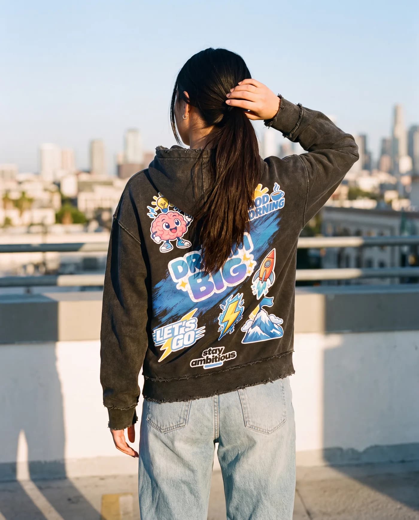 Dream Big hoodie on a rooftop at golden hour